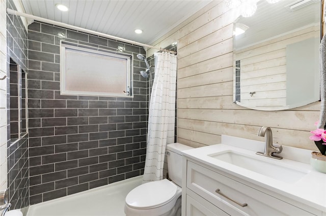full bath with wooden walls, toilet, tiled shower, vanity, and recessed lighting