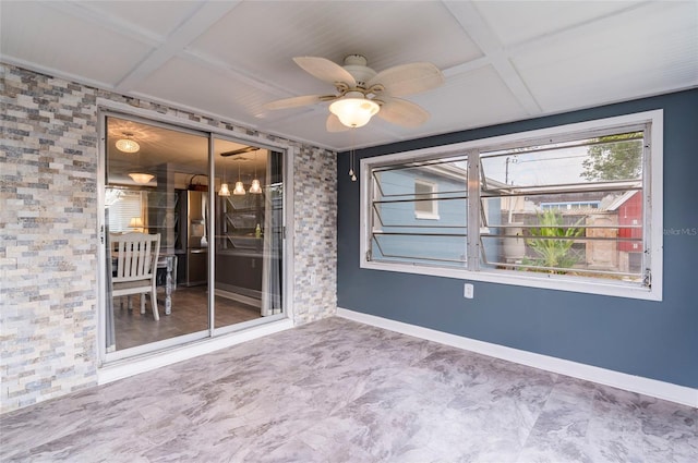 empty room featuring coffered ceiling, a ceiling fan, and baseboards