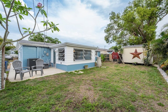 back of property featuring a patio area, a storage unit, central AC, and an outdoor structure