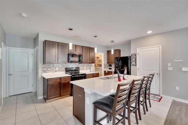 kitchen with black appliances, a sink, backsplash, light tile patterned floors, and recessed lighting