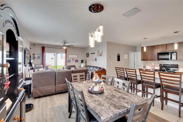 dining room featuring ceiling fan and a chandelier