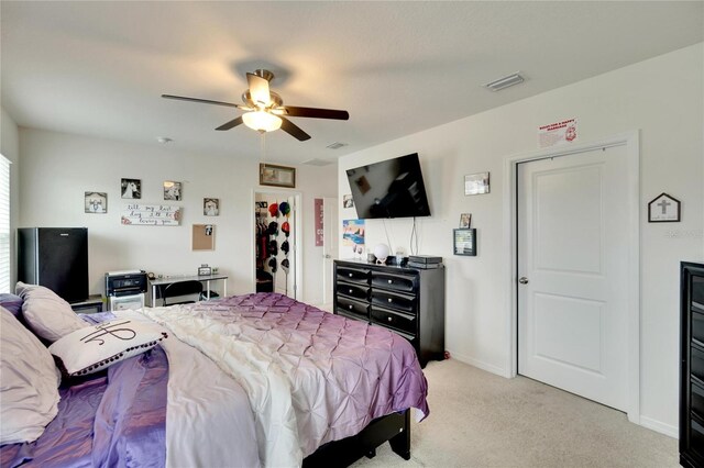 bedroom featuring light carpet, a ceiling fan, and baseboards