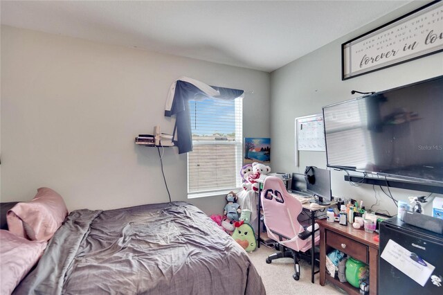 carpeted bedroom featuring an office area