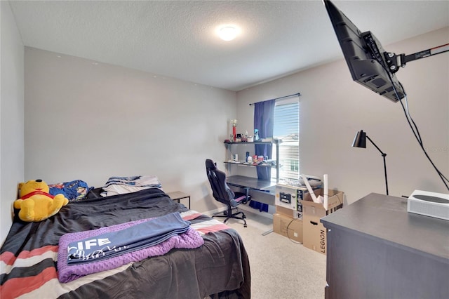 bedroom with a textured ceiling, carpet, and an office area