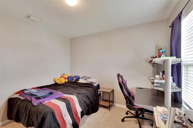 carpeted bedroom with a desk and baseboards