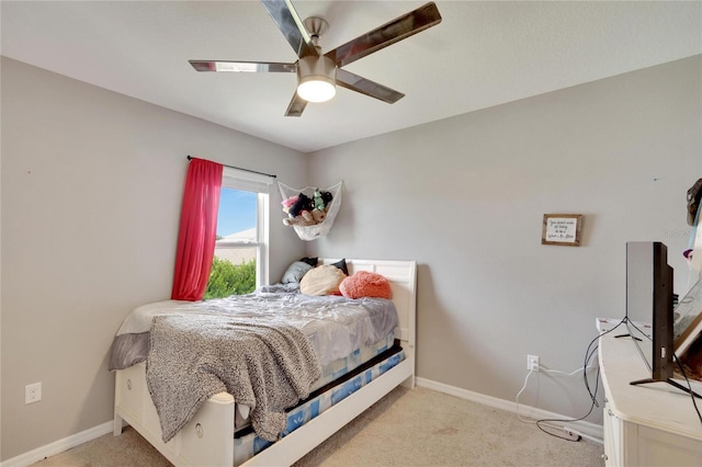bedroom with light carpet, baseboards, and ceiling fan
