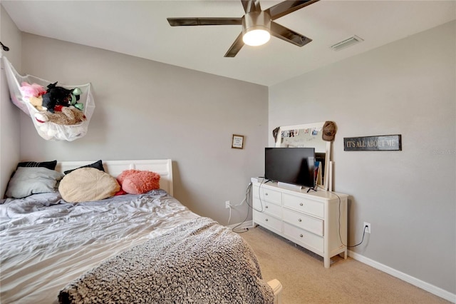 bedroom featuring light colored carpet, a ceiling fan, and baseboards