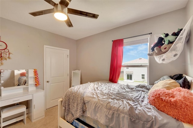 bedroom with light colored carpet and a ceiling fan