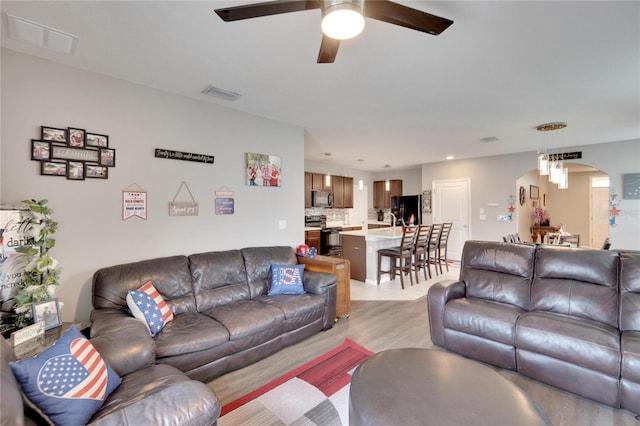 living room with a ceiling fan, light wood-style floors, and recessed lighting