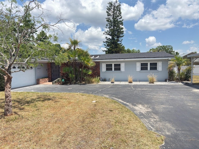 ranch-style home with driveway, a front yard, and a garage
