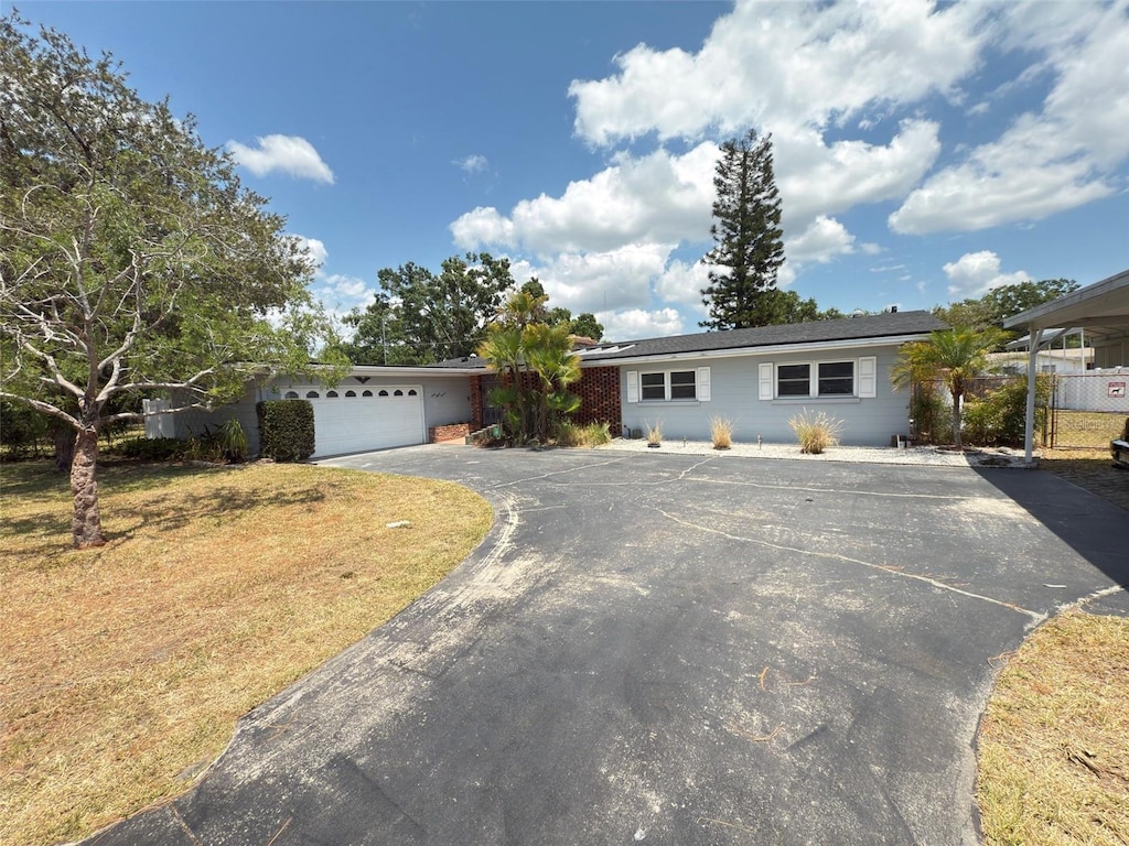 ranch-style house with aphalt driveway and a garage