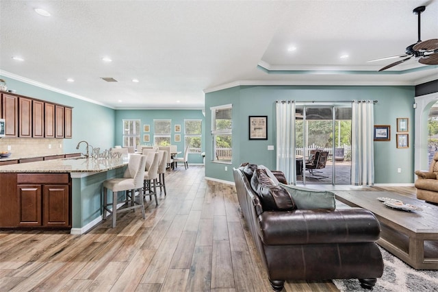 4094 Windcrest Dr, Wesley Chapel, FL 33544 - living room with light wood-style flooring, a ceiling fan, visible vents, baseboards, and ornamental molding