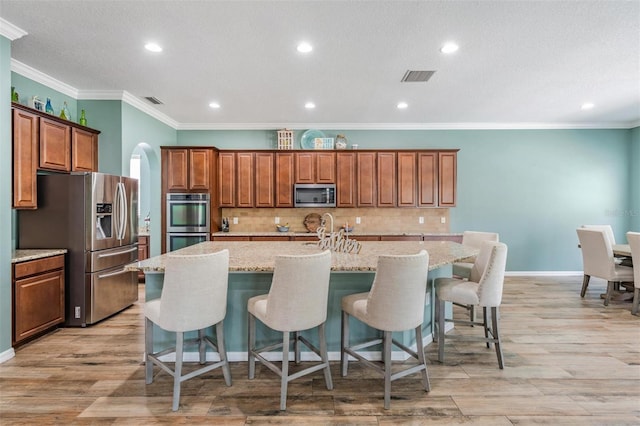 4094 Windcrest Dr, Wesley Chapel, FL 33544 - kitchen featuring backsplash, a center island with sink, visible vents, and appliances with stainless steel finishes