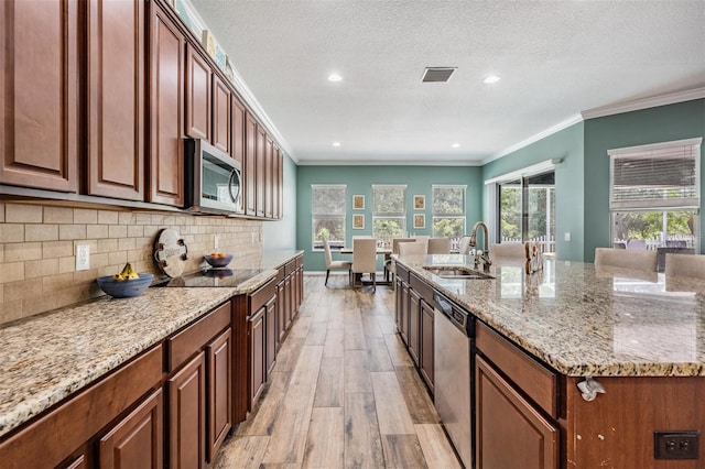 4094 Windcrest Dr, Wesley Chapel, FL 33544 - kitchen featuring light wood finished floors, a sink, stainless steel appliances, light stone countertops, and backsplash
