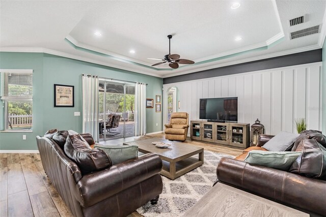 4094 Windcrest Dr, Wesley Chapel, FL 33544 - living room with hardwood / wood-style flooring, visible vents, crown molding, a ceiling fan, and a tray ceiling