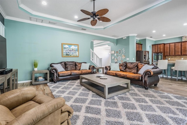 4094 Windcrest Dr, Wesley Chapel, FL 33544 - living room with ornamental molding, light wood-type flooring, ceiling fan, arched walkways, and a raised ceiling