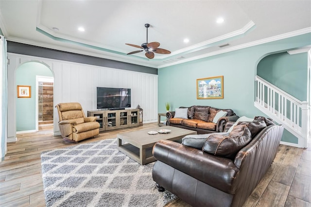 4094 Windcrest Dr, Wesley Chapel, FL 33544 - living room with wood finished floors, a tray ceiling, visible vents, ceiling fan, and arched walkways