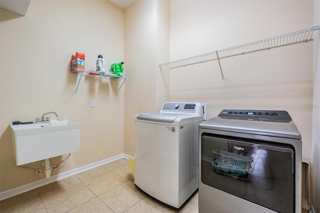 4094 Windcrest Dr, Wesley Chapel, FL 33544 - laundry area with washer and dryer, light tile patterned floors, a sink, laundry area, and baseboards