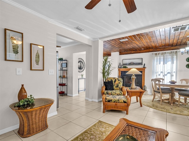 living room featuring ornamental molding, a ceiling fan, light tile patterned floors, and visible vents