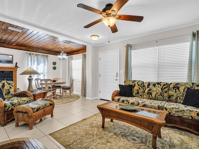 living room featuring ceiling fan with notable chandelier, visible vents, crown molding, light tile patterned floors, and baseboards