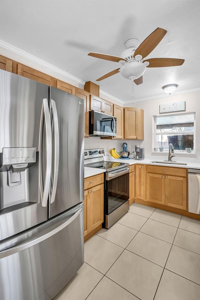 kitchen with light tile patterned floors, ornamental molding, a sink, light countertops, and appliances with stainless steel finishes
