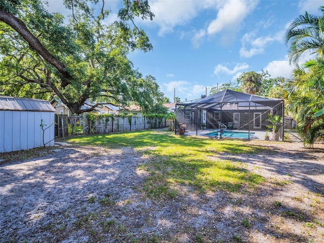 view of yard with an outdoor structure, a fenced backyard, a shed, a fenced in pool, and glass enclosure