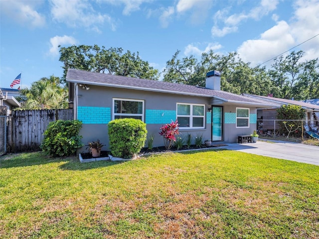 ranch-style home with fence, stucco siding, a chimney, and a front yard