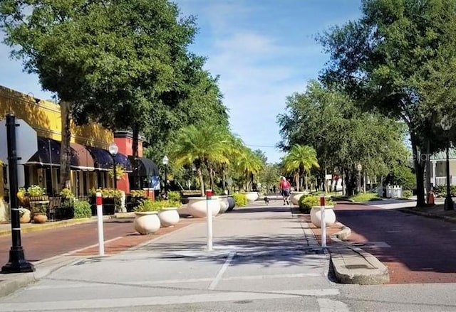 view of street featuring street lighting, sidewalks, curbs, and traffic signs