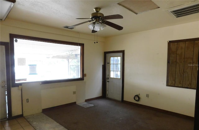 foyer entrance featuring baseboards, ceiling fan, and visible vents