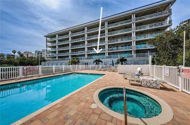 community pool featuring a patio, a community hot tub, and fence