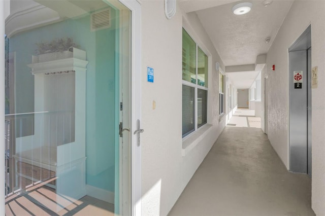 corridor featuring elevator and visible vents