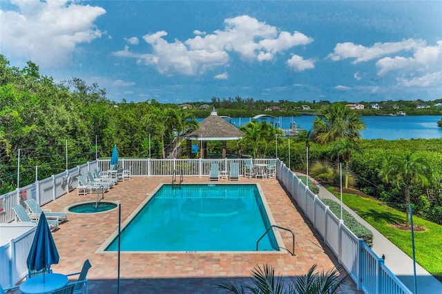 community pool featuring fence, a water view, a gazebo, and a patio