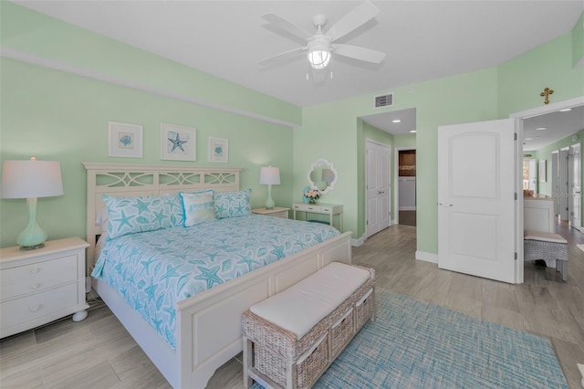bedroom featuring a closet, wood finished floors, visible vents, ceiling fan, and baseboards