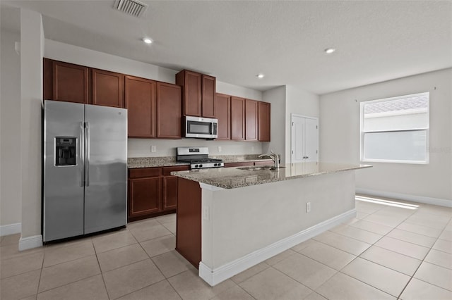 2432 Hearth Dr, Odessa, FL 33556 - kitchen with stainless steel appliances, a sink, light stone counters, baseboards, and a kitchen island with sink