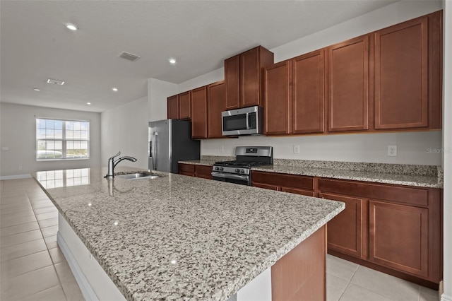 2432 Hearth Dr, Odessa, FL 33556 - kitchen with stainless steel appliances, a sink, light tile patterned floors, an island with sink, and light stone countertops