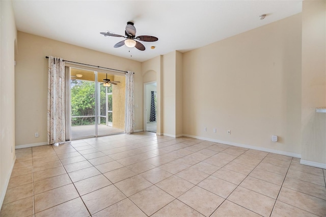 unfurnished room featuring a ceiling fan, baseboards, and light tile patterned floors