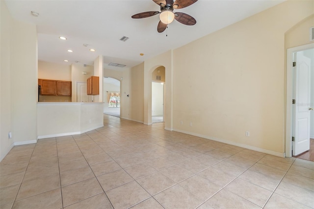 unfurnished living room with recessed lighting, visible vents, ceiling fan, light tile patterned flooring, and arched walkways