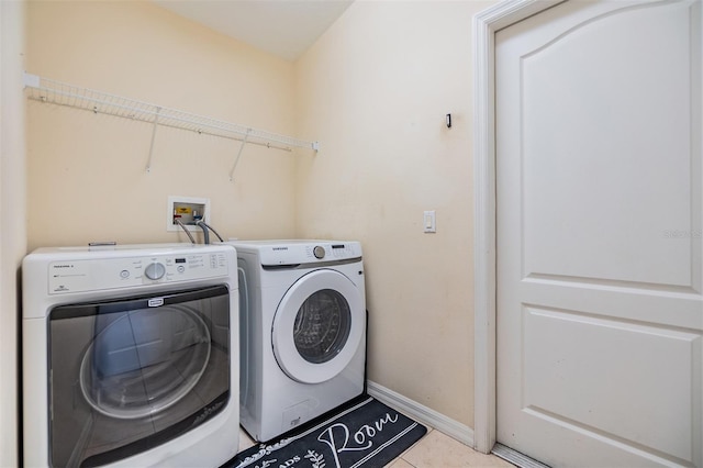 laundry room with washer and clothes dryer, laundry area, baseboards, and tile patterned flooring