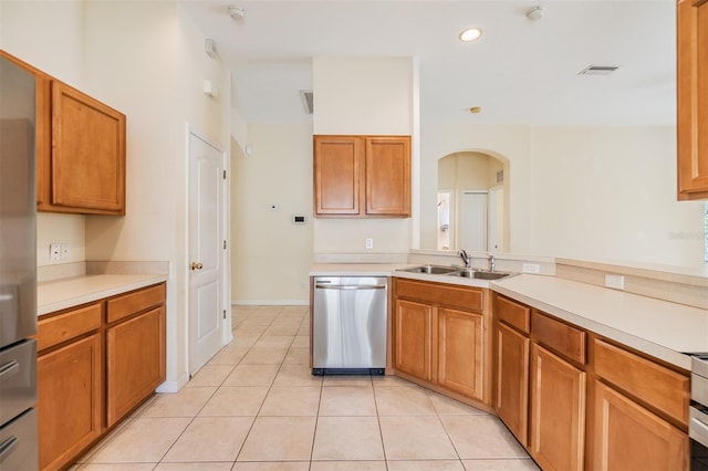 kitchen featuring visible vents, a sink, arched walkways, light countertops, and appliances with stainless steel finishes