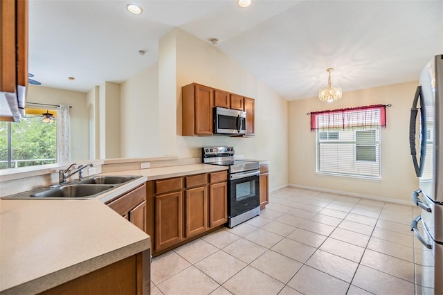 kitchen featuring brown cabinetry, stainless steel appliances, a sink, and plenty of natural light