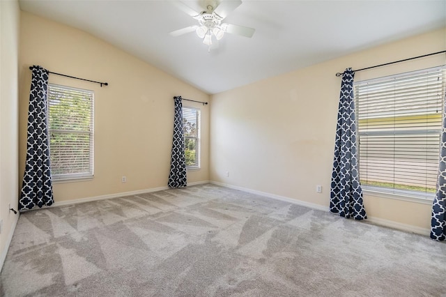 carpeted empty room featuring plenty of natural light, baseboards, a ceiling fan, and lofted ceiling