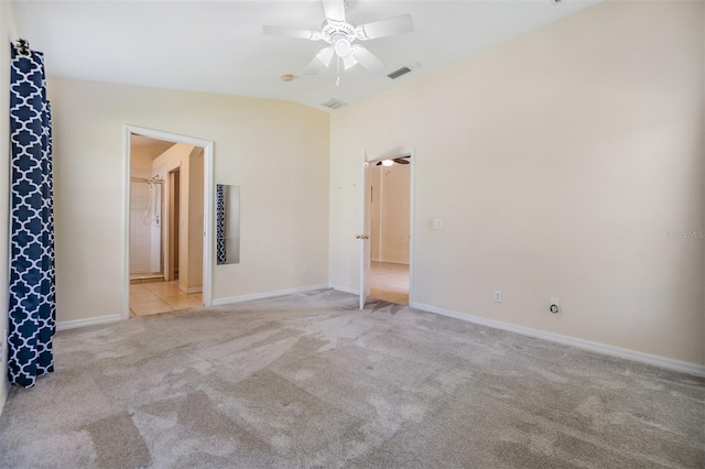 empty room featuring a ceiling fan, visible vents, baseboards, light colored carpet, and lofted ceiling