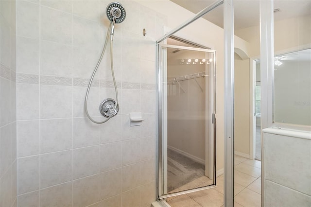 full bathroom with a shower stall, tile patterned flooring, and a spacious closet