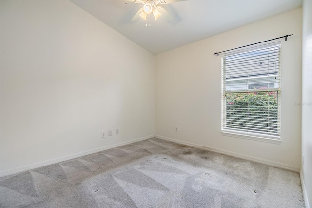 empty room featuring light carpet, baseboards, a ceiling fan, and lofted ceiling
