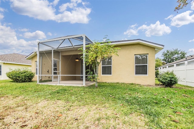 back of house featuring stucco siding, fence, a lawn, and a patio area