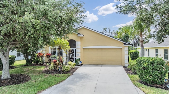 view of front facade with concrete driveway, an attached garage, stucco siding, and a front yard