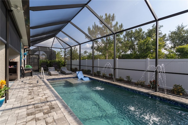 view of pool with a patio, a fenced backyard, and glass enclosure