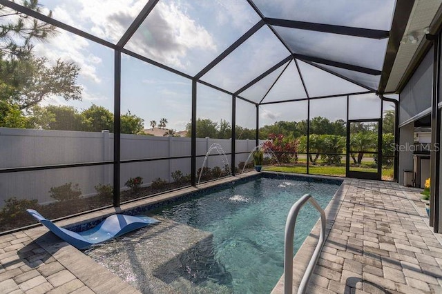 view of swimming pool featuring a fenced backyard, a patio, and glass enclosure