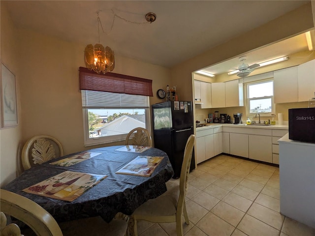 5930 Bahama Way N, St Pete Beach, FL 33706 - kitchen with freestanding refrigerator, a chandelier, light countertops, white cabinets, and light tile patterned floors
