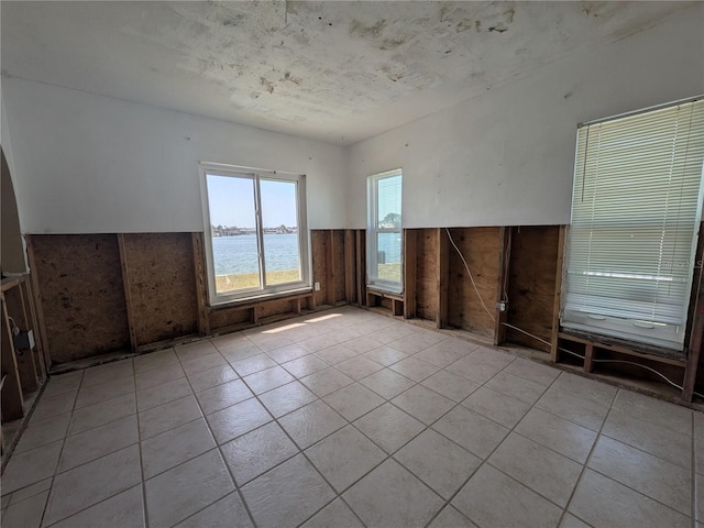 5930 Bahama Way N, St Pete Beach, FL 33706 - tiled empty room with a wainscoted wall and a water view